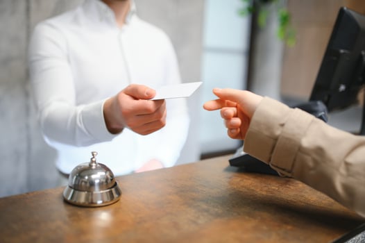 Close up of hand guest takes room key at check-in desk of the hotel. Hotel concept photo