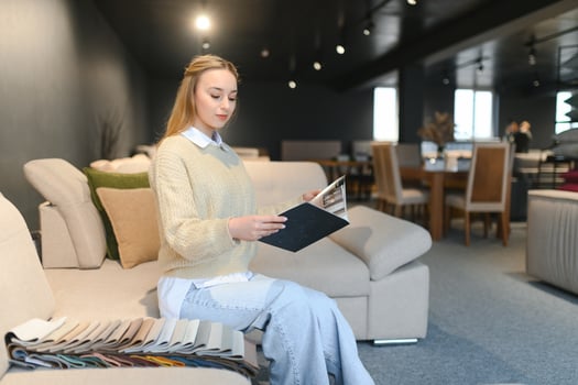 Woman designer at furniture store looking at textile swatch photo
