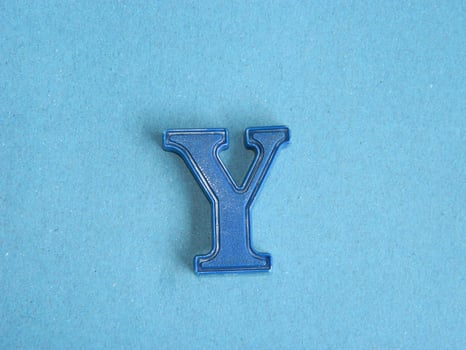 Macro photo or closeup photo of the alphabet from children's toys on a blue background. Use on preschool also