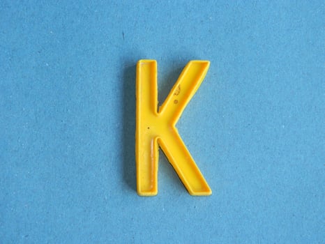 Macro photo or closeup photo of the alphabet from children's toys on a blue background. Use on preschool also
