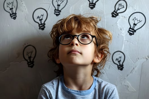 Child look up a light bulb in the classroom, concept of ideas and creativity. photo