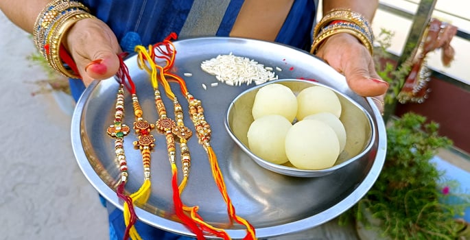 Indian Sister holding a plate of rakhi and sweets on the occasion of Raksha Bandhan photo