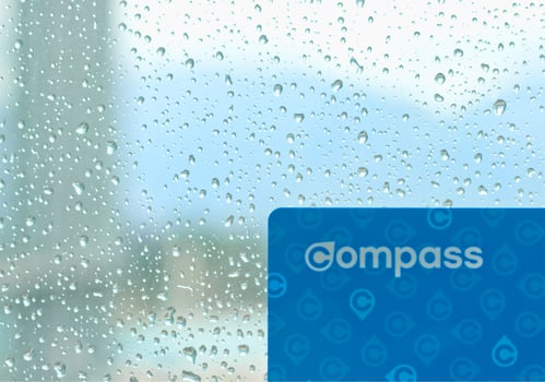 Vancouver, Canada - September 12, 2019 - Compass card against the window with water drops on it during the rainfall in Vancouver photo
