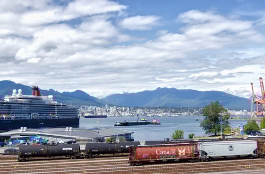 Vancouver, Canada - June 10, 2019 View of West Coast Express Railroad and Cruise ship near Canada Place. North Vancouver surrounded by mountains in the background photo