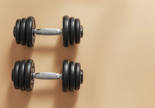 Single Black Dumbbell On A Beige Background photo