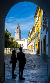 Young couple admiring the Giralda tower from the Patio de Banderas square, Seville, Spain photo