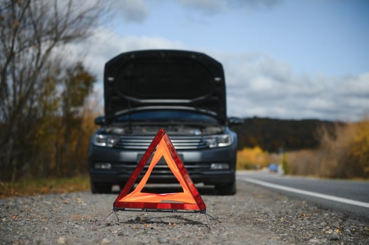 breakdown triangle stands near a broken car. photo