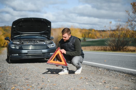 Handsome young man with his car broken down by the roadside photo