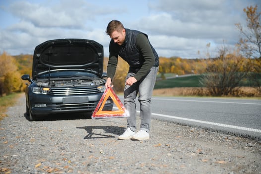 A young man with a black car that broke down on the road,copy space. photo