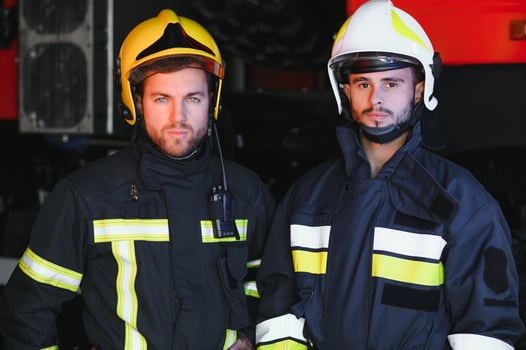 Portrait of two heroic fireman in protective suit and helmet. photo