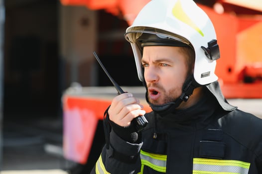 Fireman, firefighter in action standing near a firetruck. Emergency safety. Protection, rescue from danger. photo