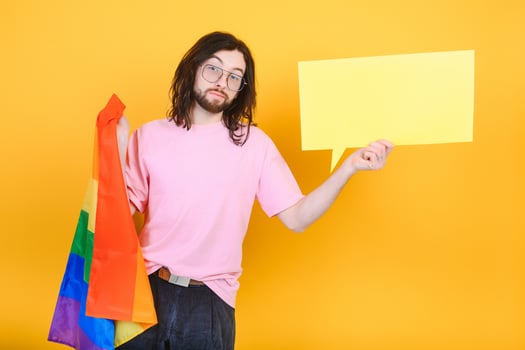 Gay man hold rainbow striped flag isolated on colored background studio portrait. People lifestyle fashion lgbtq concept photo