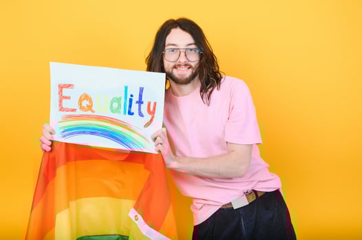 Attractive gay caucasian man holding a protest sign during a LGBT pride parade. Equality. photo