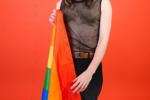 Gay man hold rainbow striped flag isolated on colored background studio portrait. People lifestyle fashion lgbtq concept photo