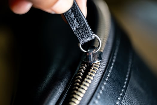 Hand Holding Zipper on Black Leather Bag photo