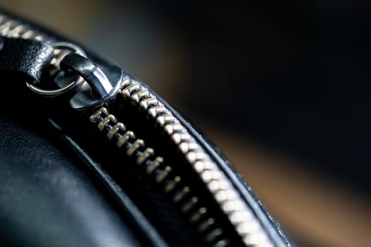 Close-up of metallic zipper on black leather photo
