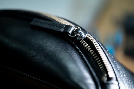 Black leather bag with silver zipper close-up photo