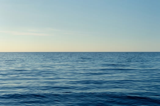 Tranquil Ocean Surface Under Clear Blue Sky photo
