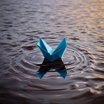 A paper boat floating on water photo