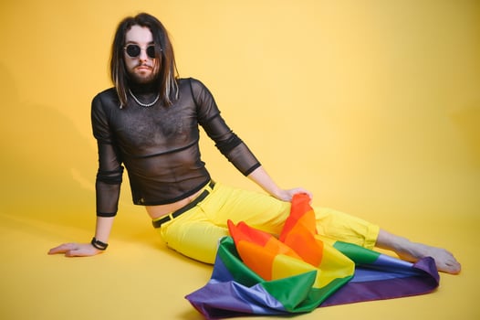 Gay man hold rainbow striped flag isolated on colored background studio portrait. People lifestyle fashion lgbtq concept photo