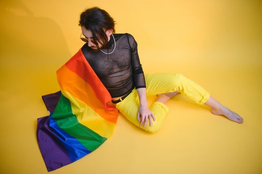 Gay man hold rainbow striped flag isolated on colored background studio portrait. People lifestyle fashion lgbtq concept photo