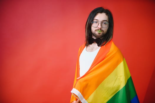 Youth transgender LGBT with Rainbow flag on shoulder isolated color background. gender expression pride and equality concept. photo