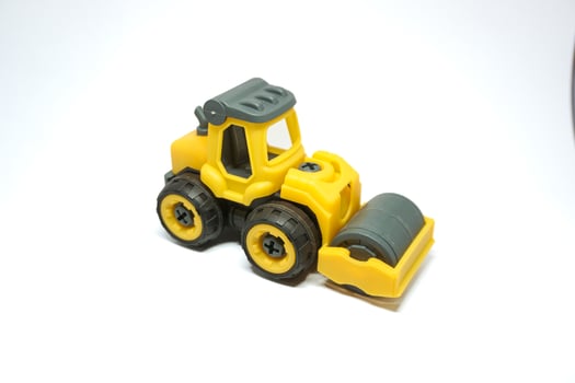 yellow tendem roller toy on white background. Tandem roller or road roller toy for kids photo
