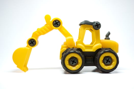 Kids excavator toys. Yellow mini excavator for children learning photo
