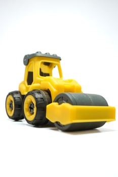 yellow tendem roller toy on white background. Tandem roller or road roller toy for kids photo