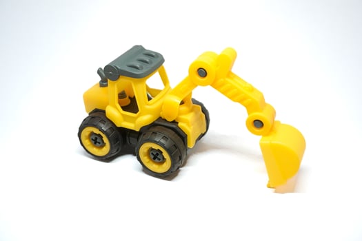 Kids excavator toys. Yellow mini excavator for children learning photo