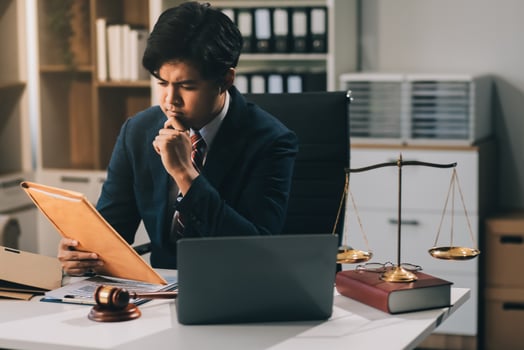 Male lawyer working with contract papers and wooden gavel on tabel in courtroom. justice and law ,attorney, court judge, concept. photo
