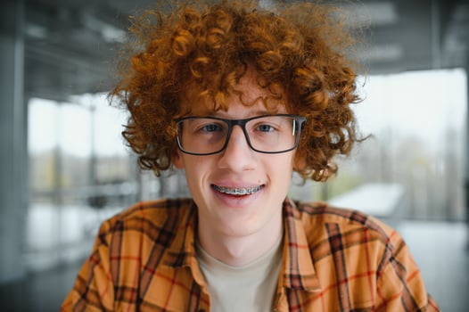 cute red-haired guy wearing stylish glasses yellow t-shirt. photo
