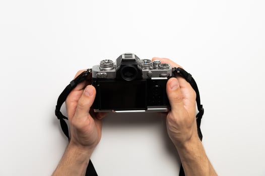 Digital SLR camera in retro style in male hands on a white background photo