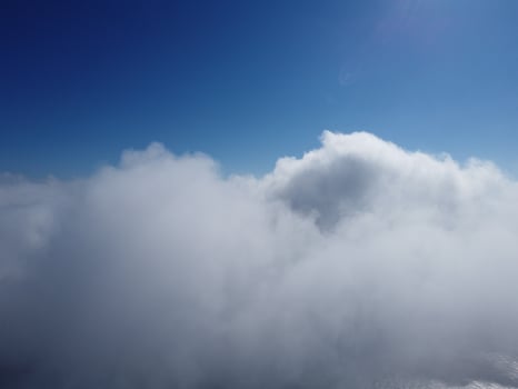 Aerial view. The drone flies over foggy and fluffy clouds. Blue sky sun and sea fog. Abstract aerial nature summer ocean sunset sea and sky background. Vacation, travel and holiday concept photo