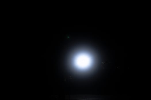 spot light bulb shin in middle of the dark black background with Silhouette House residential area photo
