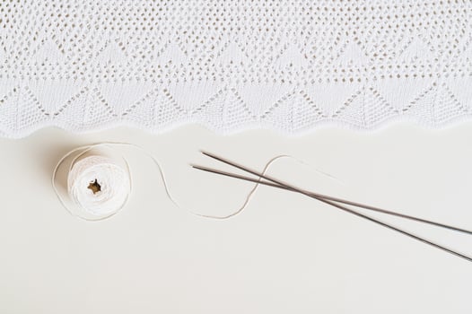 Knitting background, finished texture, ball and knitting needles on a light background top view photo