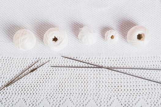 Background knitting balls, hooks and knitting needles on knitted texture top view photo