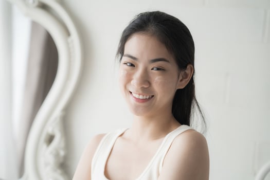 Beautiful Asian Young Woman Her Perfect Soft Face Skin, Uses Advanced Organic Cream, Smiles Look at Camera. Happy Female Enjoying Her Morning Beauty Routine, Natural Beauty, Cosmetic Products photo