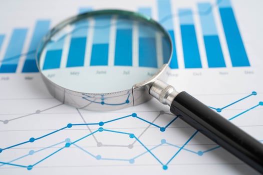 Magnifying glass on graph. Finance business and trading. photo