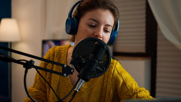 Creative blogger wearing headphones checking sound before talking with fans during live on social media, podcasting. On-air online production internet broadcast show host streaming live content photo