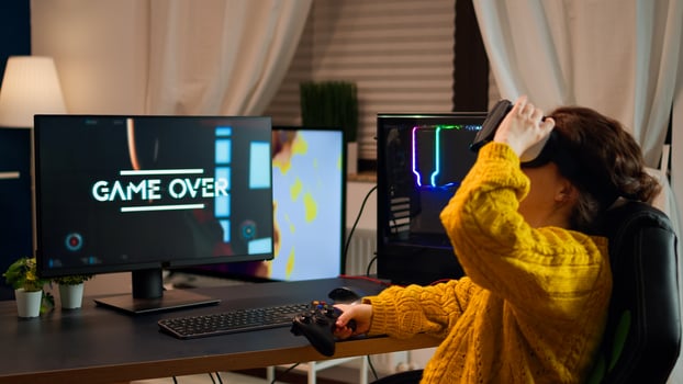 Angry woman wearing VR headset getting off after losing at online shooter game. Virtual shooter game championship in cyberspace, esport player playing with wireless controller during gaming tournament photo