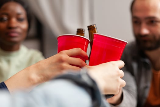 Close up of multi ethnic friends celebrating friendship during gathering. Group of multiracial people spending time together sitting on couch late at night in living room. photo