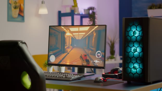 Gaming room no people in equiped with RGB powerful personal computer for online videogames tournament and gaming chair, first-person shooter game on screen. Cozy room with neon light. photo