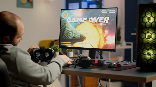 Videogamer losing graphics cyberspace game sitting on gaming chair using wireless controller and VR headset playing on powerful computer. Sad pro cyber man streaming online championship photo