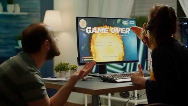 Gaming over for nervous pro couple gamers, playing space shooter during virtual competition tournament using professional headset. Sad online streaming cybers performing using RGB powerful computer. photo