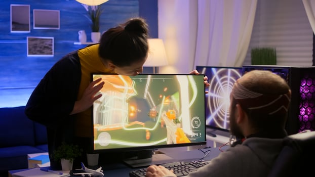 Cyber gamer fight with girlfriend about playing first person shooter game for online competition. Pro player performing on powerful pc in gaming room home during online tournament photo