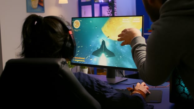 Couple of gamers playing multiplayer game on powerful computer at home with professional headphones. Online streaming cyber performing during gaming tournament using technology network wireless photo