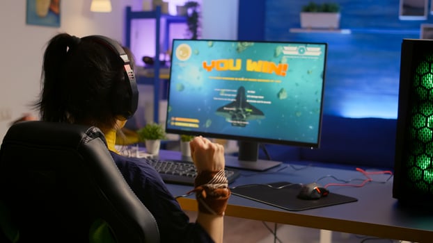 Player winning space shooter esport tournament wearing professional headset. Cyber performing on powerful computer late at night in gaming room home during online tournament photo
