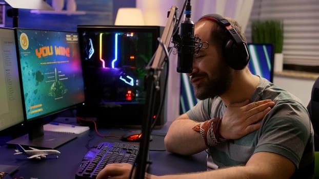 Winner streamer playing online space shooter game in gaming room using RGB keyboard and system desktop. Cyber performing on powerful pc talking with players on chat open during live competition photo