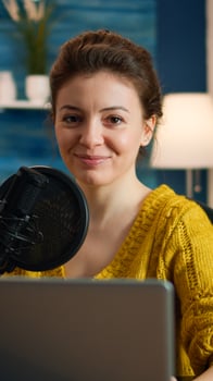 Social media influencer smiling at camera sitting in home studio ready for streaming new podcast. On-air online production internet broadcast show host streaming live content record digital blog photo